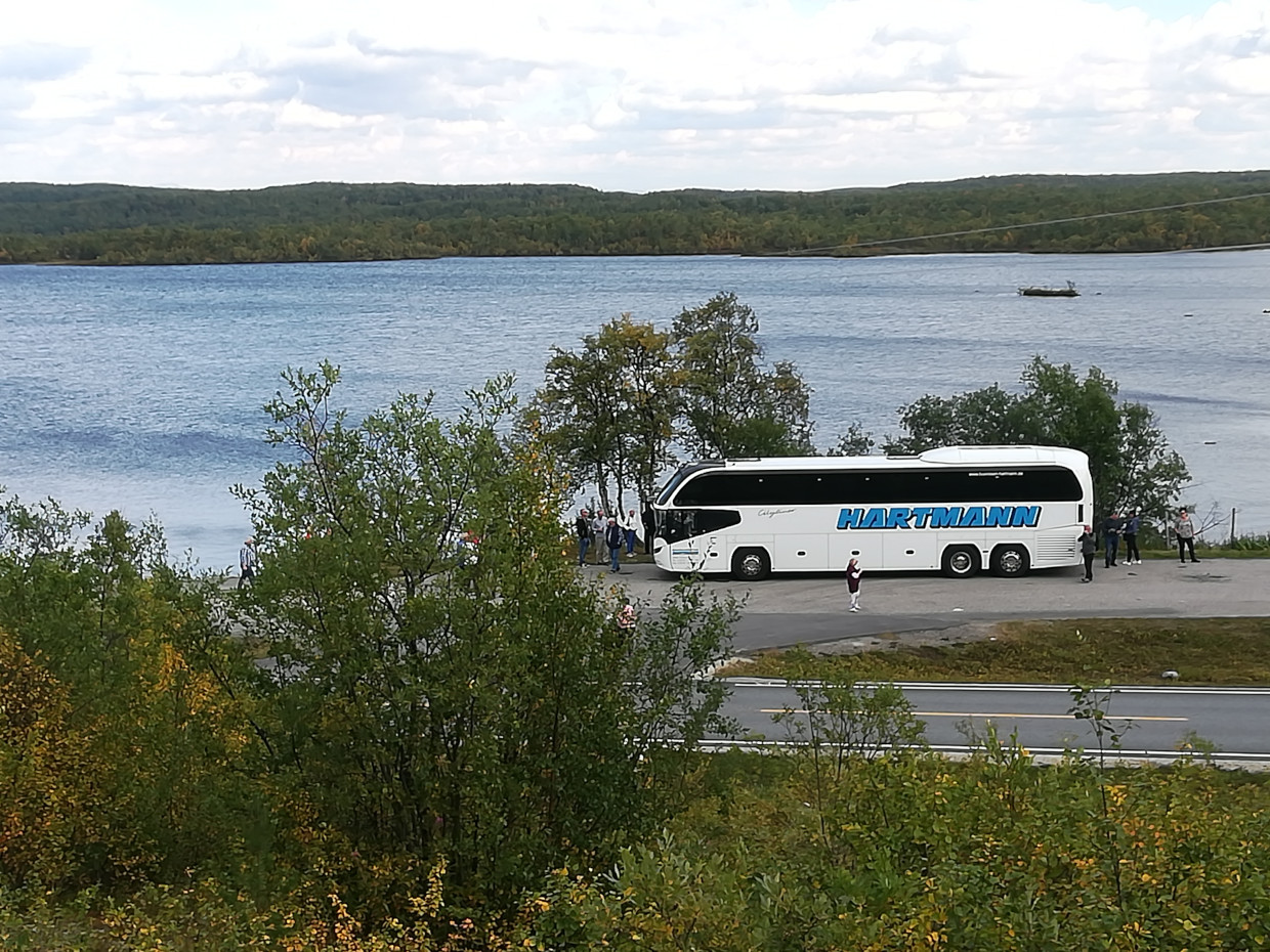 weißer Bus vor See